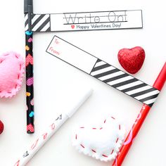 valentine's day writing and crafting supplies laid out on a white surface