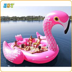 a pink inflatable flamingo floating on the water with several people around it