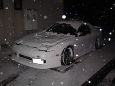 a car is covered in snow on the street