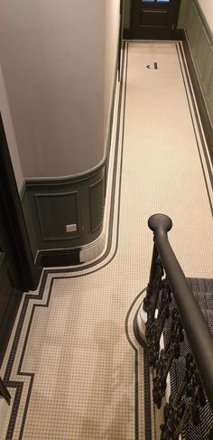 an overhead view of a hallway with stairs and tiled flooring, looking down at the door