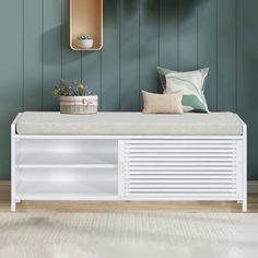 a white bench sitting in front of a mirror on top of a wooden wall next to a plant