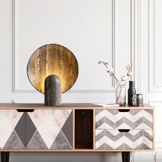 a sideboard with two drawers and some vases on it