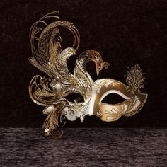 Phoenix Mask Papier-mâché mask, with metal insert. Venetian mask for wearing and decoration - Traditional and original Venetian mask made of papier-mâché, handmade and decorated with metal insert, gold leaf and glitter, enriched with Swarovski crystals. Size: All our masks are handmade papier-mâché masks made in Venice. Our decorators use traditional Venetian techniques such as stucco, acrylics, gold and silver leaf, macramé, trimmings, glitter and crequelé to offer you a wide range of original Phoenix Mask, Gold Masquerade Mask, Mask Ball, Paper Mache Mask, Venice Mask, Venetian Masquerade Masks, Dragon Mask, Ball Mask, Masked Ball