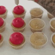 cupcakes with red frosting sitting on top of a white table next to each other