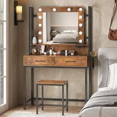 a bedroom with a vanity, mirror and lights on it's side table in front of a bed