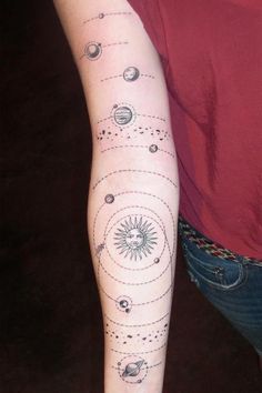 a woman with a tattoo on her arm that has planets and sun in the middle