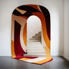 a white staircase with an orange and red carpet