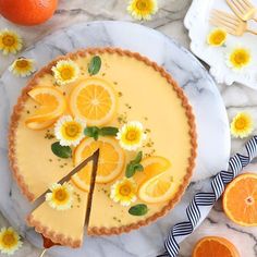 there is a pie with oranges and daisies on it