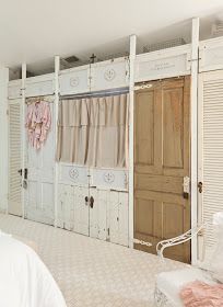 a bedroom with white walls and wooden doors