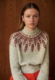 a woman in a white sweater and red skirt