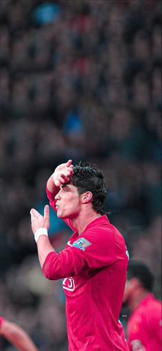 a man in red shirt throwing a frisbee at a soccer game with other people watching