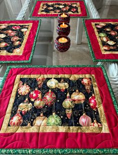 four quilted placemats with lit candles on them in front of white pillars