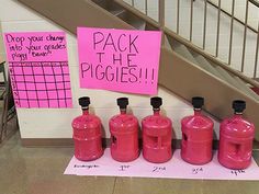 pink propane gas bottles are lined up in front of a sign that says pack the piggies