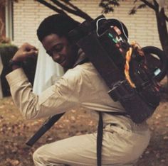 a man with a backpack on his back is squatting in front of a house