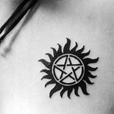 a black and white photo of a sun with a pentagramil tattoo on it