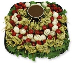 a platter filled with skewered vegetables and meatballs