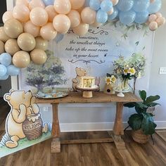 a winnie the pooh themed birthday party with balloons and desserts on a table