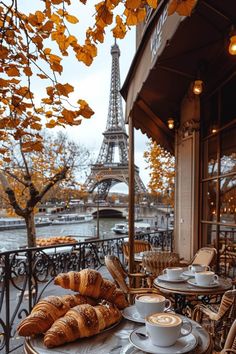 coffee and croissants on an outdoor table in front of the eiffel tower