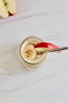 an apple and cinnamon smoothie in a mason jar with a spoon on the side