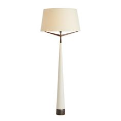 a floor lamp with a white shade on it's side and a brown base