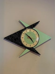 a clock that is on the side of a wall with an origami design