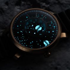 a close up of a wrist watch with blue lights on it's dials