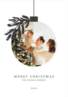 a merry christmas card with an image of a man and woman decorating a tree