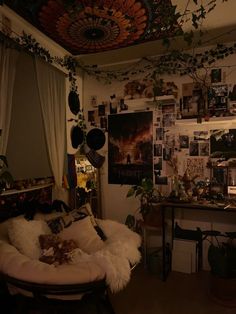 a living room filled with furniture and lots of pictures on the wall next to a desk