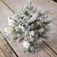 a bouquet of white flowers sitting on top of a wooden table