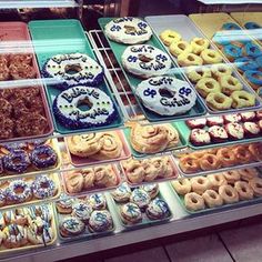 a display case filled with lots of different types of doughnuts and pastries