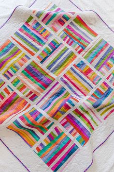 a multicolored quilt on a white blanket