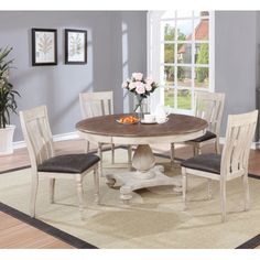 a dining room table with four chairs around it