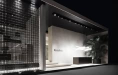 the entrance to an office building at night with lights shining on the walls and floor