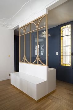 a white bench sitting in front of a window on top of a hard wood floor