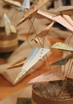 some paper airplanes are sitting on top of a wooden table and it looks like they have been made out of wood