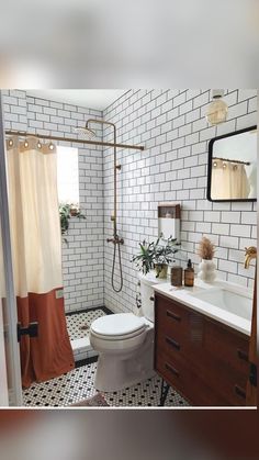 a white toilet sitting next to a bathroom sink under a mirror and shower faucet