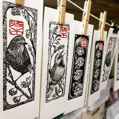 several cards are hanging on the clothesline in front of some paper clips with birds and flowers