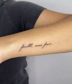 a person with a tattoo on their arm that says faith over fear