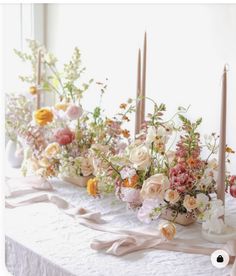 a table with flowers and candles on it