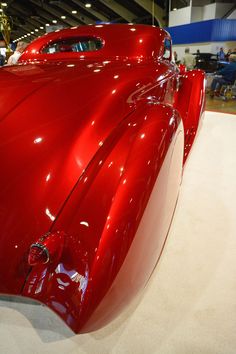 an antique red car on display in a museum