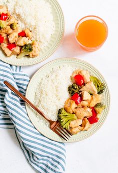 two plates with rice, broccoli and chicken next to a glass of orange juice