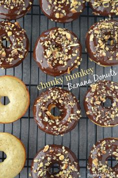 there are many chocolate donuts on the cooling rack with nuts and sprinkles