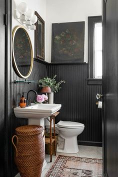 a white toilet sitting next to a sink in a bathroom under a large framed mirror