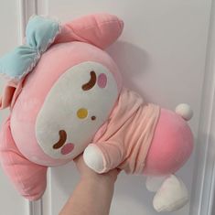 a person is holding a pink stuffed animal