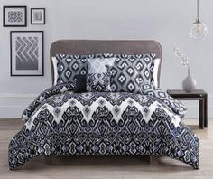 a bed with blue and white comforters in a room