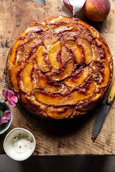 an apple pie on a wooden table next to some flowers