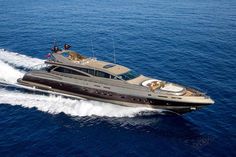 a large brown boat in the middle of the ocean with people on it's deck