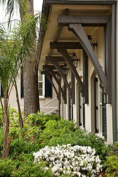 an outside view of a house with white flowers and trees