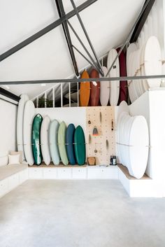 there are many surfboards on the wall in this room