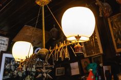 two lamps hanging from the ceiling in a room with pictures and other items on it